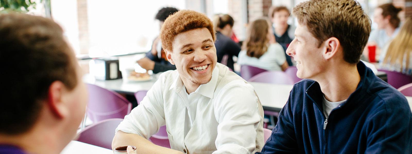 students laughing in campus coffee shop